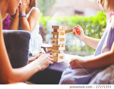 Mother and children playing wooden blocks tower Mother and children playing wooden blocks tower 27272355