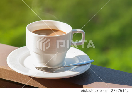 White cup of hot coffee on balcony with natural background. White cup of hot coffee on balcony with natural background. 27276342