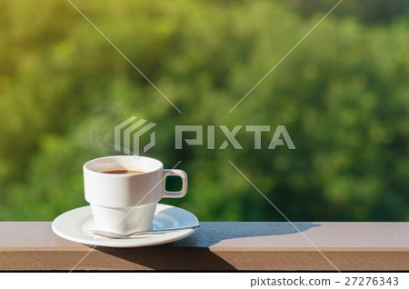 White cup of hot coffee on balcony with natural background. 27276343