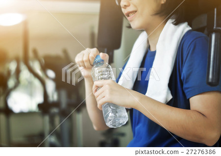 Asian woman holding bottle of water after workout. Asian woman holding bottle of water after workout. 27276386