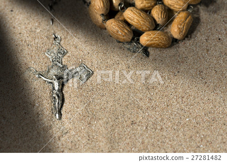 Silver Crucifix with Rosary Beads on Sand Silver Crucifix with Rosary Beads on Sand 27281482