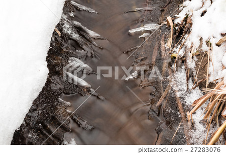 Small stream with thin layers of ice forming on Small stream with thin layers of ice forming on 27283076