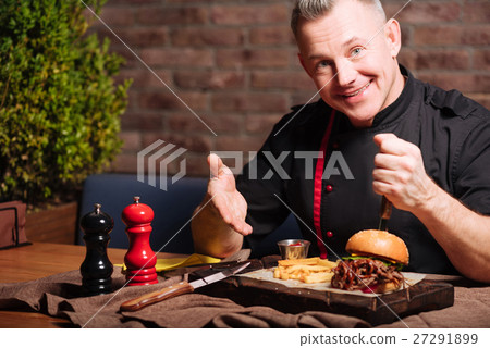 Happy man eating burger in restaurant Happy man eating burger in restaurant 27291899