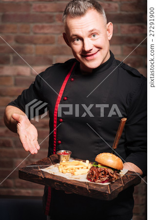 Close up of mans hands holding a tray with burger Close up of mans hands holding a tray with burger 27291900