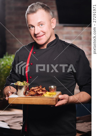 Smiling man holding a tray with bacon Smiling man holding a tray with bacon 27291971
