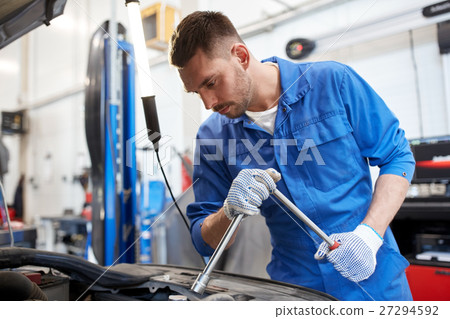 mechanic man with wrench repairing car at workshop 27294592