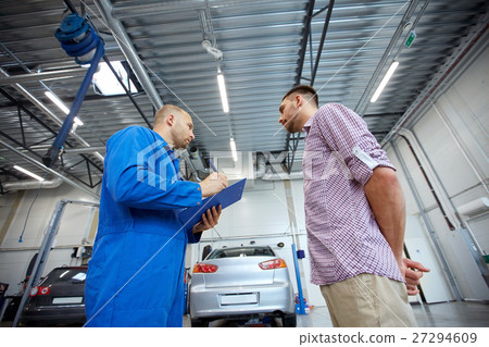 auto mechanic with clipboard and man at car shop 27294609