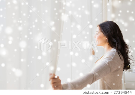 close up of woman opening window curtains 27294844