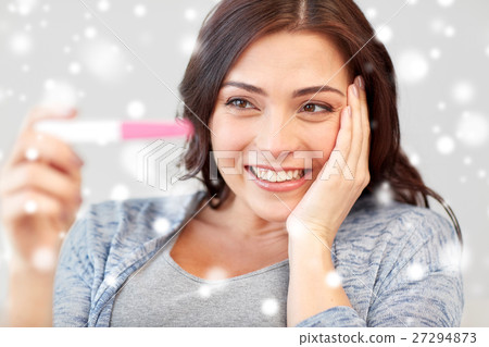happy woman looking at home pregnancy test 27294873