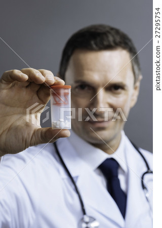 Handsome doctor holding box with medicine Handsome doctor holding box with medicine 27295754