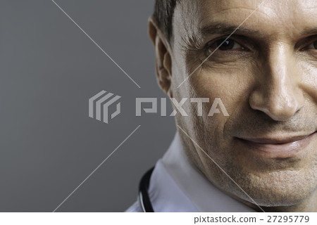Close up of handsome doctor smiling on a grey Close up of handsome doctor smiling on a grey 27295779