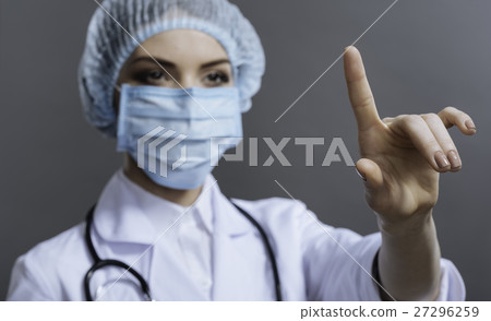 Pretty doctor gesturing on grey background Pretty doctor gesturing on grey background 27296259