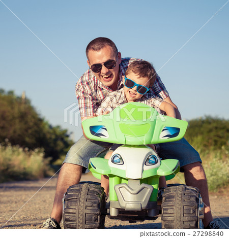 Father and son playing on the road at the day time. Father and son playing on the road at the day time. 27298840