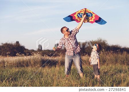Father and son playing at the park at the sunset time. Father and son playing at the park at the sunset time. 27298841