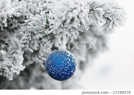 Blue ball on branch of a Christmas tree in frost 27299576