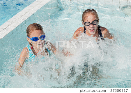 Two happy children playing on the swimming pool at the day time. 27300517
