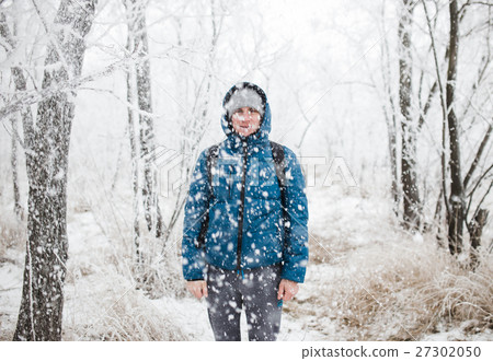 Young handsome man standing in snowfall on 27302050