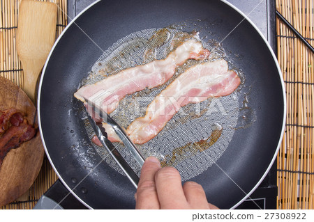 Chef frying bacon in the pan 27308922