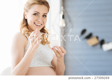 Pregnant woman eating tasty yoghurt 27309269