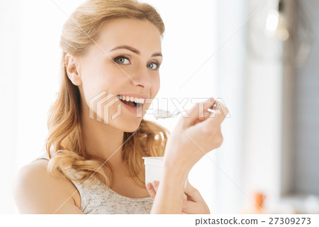 Young pregnant woman eating yoghurt 27309273