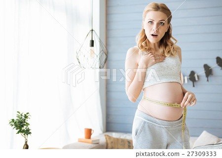Pregnant woman measuring her tummy Pregnant woman measuring her tummy 27309333