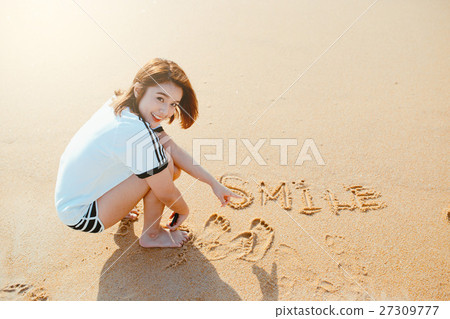 Bueatiful girl write word in the sand on the beach. Bueatiful girl write word in the sand on the beach. 27309777