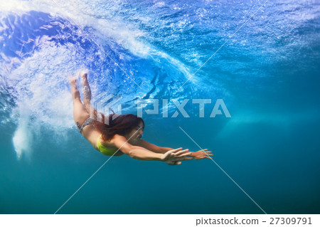 Young woman swim underwater, dive under ocean wave Young woman swim underwater, dive under ocean wave 27309791