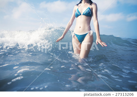 Woman standing in waves at beach Woman standing in waves at beach 27313206