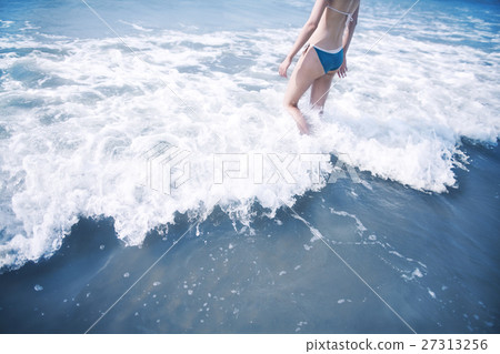 Woman walking into waves at the beach 27313256