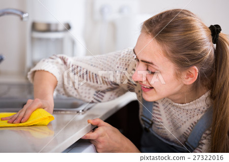 young girl dusting surfaces in residential kitchen young girl dusting surfaces in residential kitchen 27322016