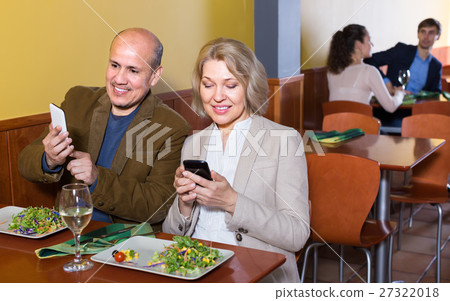 Couple taking photoes of meal . 27322018