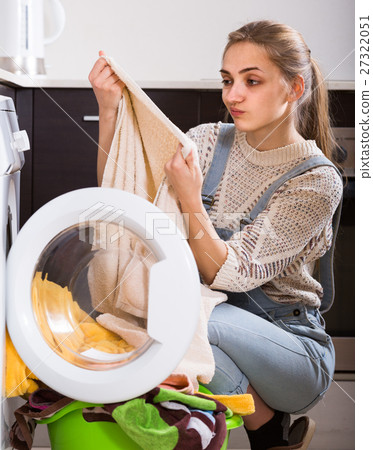 Portrait of housewife taking dirty clothes out washer Portrait of housewife taking dirty clothes out washer 27322051