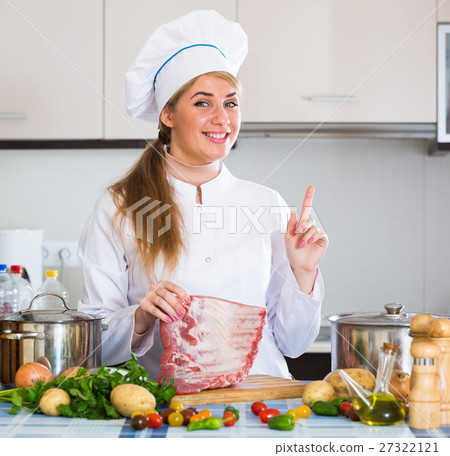 Professional female cook with ribcage in kitchen Professional female cook with ribcage in kitchen 27322121