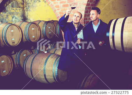 Winery employees checking up wine sample 27322775