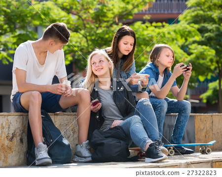 Happy girls and boys playing with mobile phones Happy girls and boys playing with mobile phones 27322823