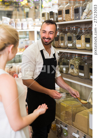 Male seller in store of ecological goods. 27323083