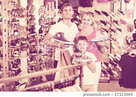 Cheerful young parents with boy in school age shopping shoes Cheerful young parents with boy in school age shopping shoes 27323084