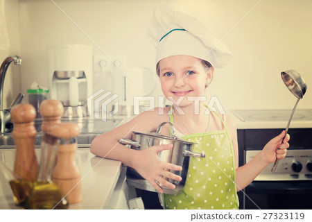 Little girl with pot at kitchen. Little girl with pot at kitchen. 27323119