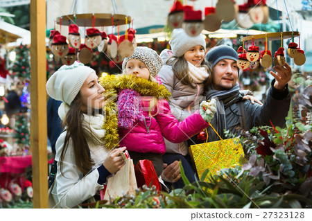 Happy smiling family of four buying Caga Tio Happy smiling family of four buying Caga Tio 27323128