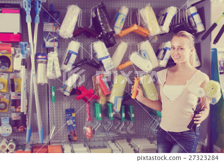 cheerful woman customer buying painting roller in household store cheerful woman customer buying painting roller in household store 27323284