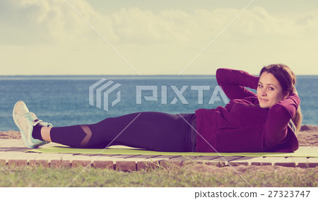 Young girl exercising on exercise mat Young girl exercising on exercise mat 27323747