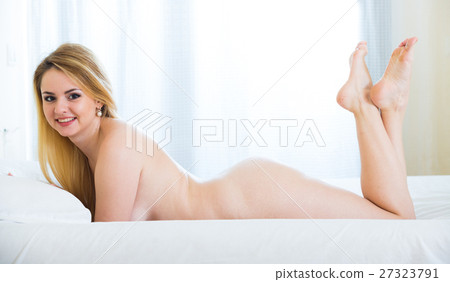 Blonde woman with naked body lounging in bedroom 27323791