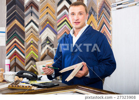 portrait of man seller working with picture frames in atelier 27323908