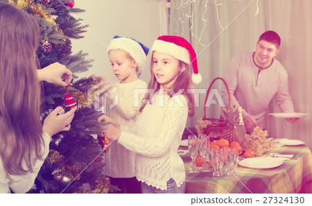 Family decorating Christmas tree at home 27324130