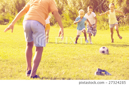 kids kicking football in park 27324285