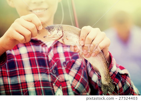 teenager boy holding catch fish on hook . teenager boy holding catch fish on hook . 27324403