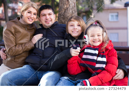 Happy family of four relaxing together 27324479