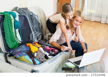 Mother with daughter near suitcase with credit card Mother with daughter near suitcase with credit card 27324496