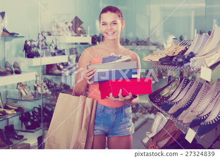positive teenager female holding boxes in shoes boutique 27324839