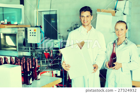 Winery workers holding carton package with wine bottles Winery workers holding carton package with wine bottles 27324932